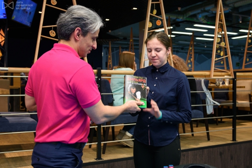 Юлия Голубева получает книгу Роберта Бирна из рук Платона Бочоришвили