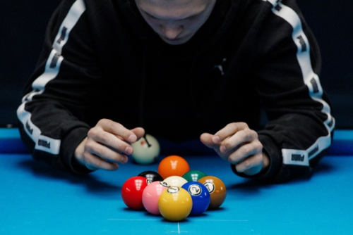 Спортсмен ставит шары так, чтобы выиграть с разбоя